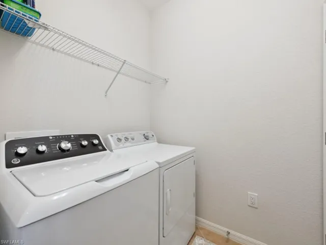 Laundry area featuring baseboards, laundry area, and washing machine and clothes dryer