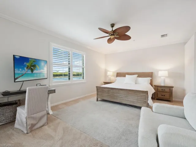 Carpeted bedroom with visible vents, baseboards, crown molding, and ceiling fan