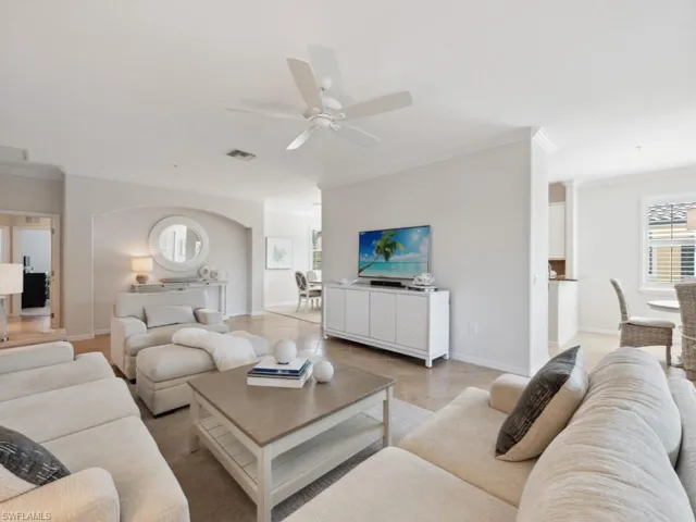 Living room with crown molding, ceiling fan, baseboards, and visible vents