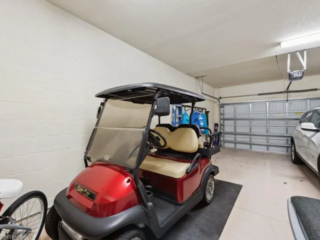 Garage featuring a garage door opener and concrete block wall