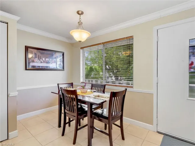 Dining space featuring crown molding and light tile patterned floors