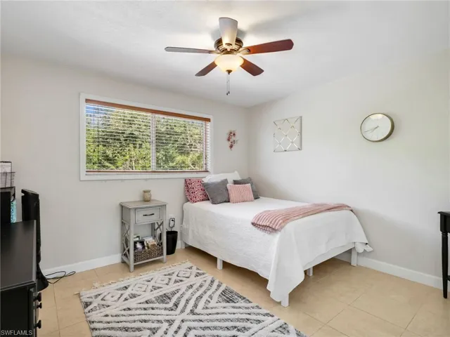 Bedroom with a ceiling fan and light tile patterned floors
