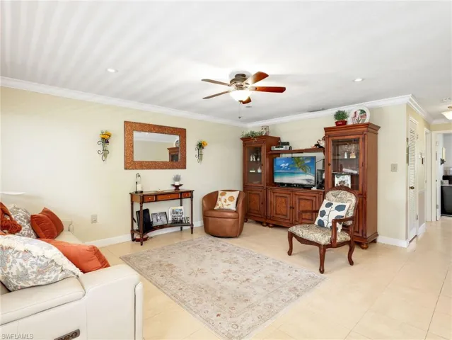 Living room featuring a ceiling fan, ornamental molding, light tile patterned flooring, and recessed lighting