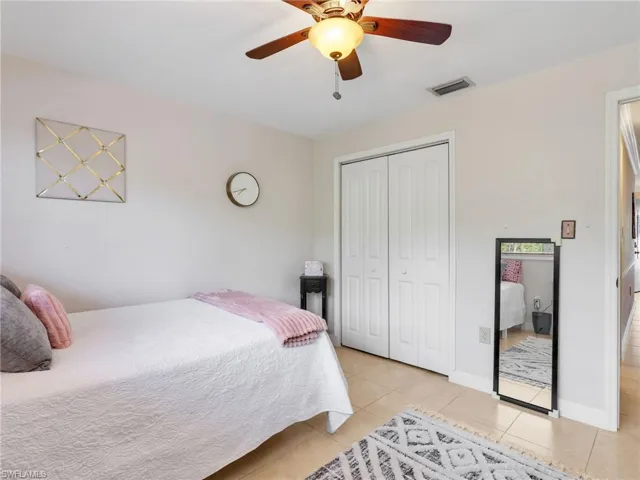 Bedroom with a closet, ceiling fan, and light tile patterned floors