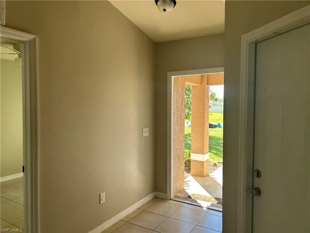 Doorway featuring tile patterned floors and baseboards