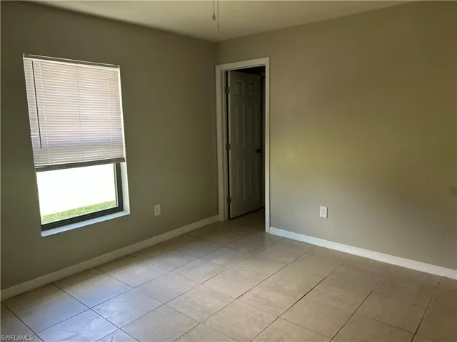 Spare room with light tile patterned floors and baseboards