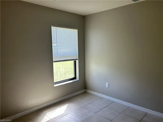 Unfurnished room featuring baseboards and light tile patterned flooring