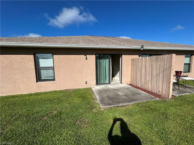 Rear view of property with a patio, stucco siding, and a shingled roof