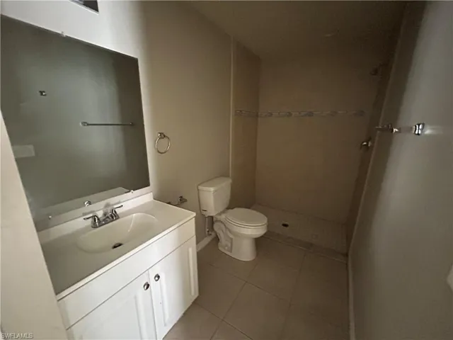 Bathroom with vanity, a shower stall, and light tile patterned floors