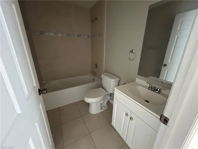 Full bath with vanity, shower / bathtub combination, and light tile patterned floors