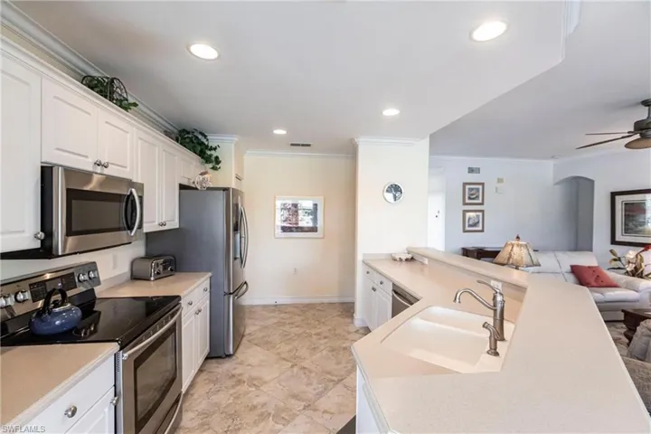 Kitchen featuring stainless steel appliances, white cabinetry
