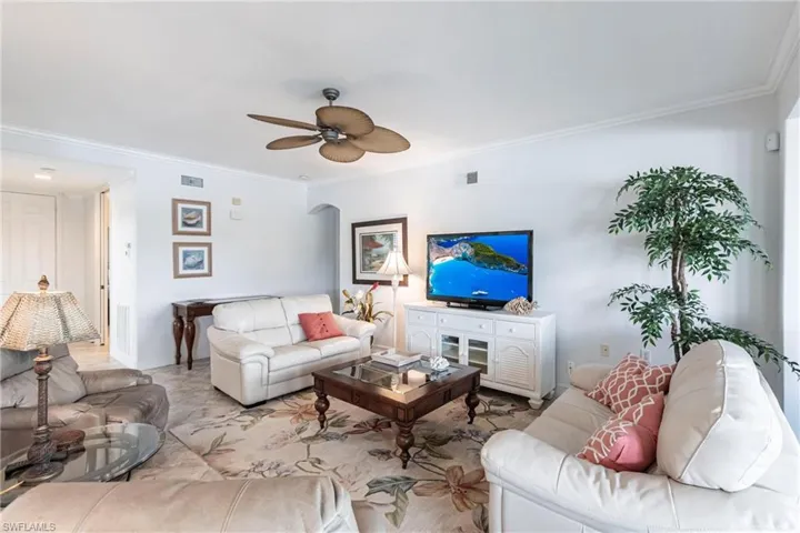 Living room featuring crown molding and ceiling fan