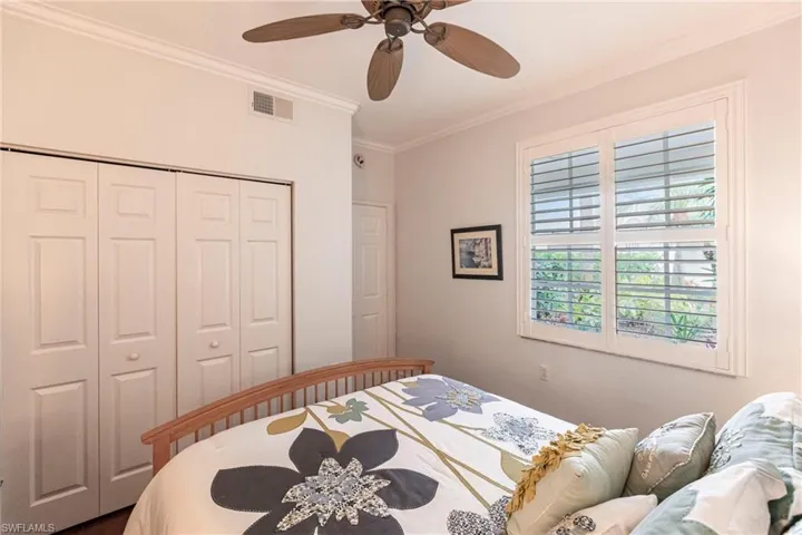 Bedroom featuring crown molding, a closet, and ceiling fan