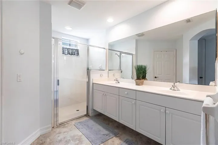 Bathroom featuring dual vanity and walk in shower