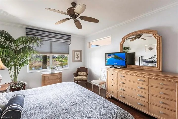 Bedroom with Elm hardwood floor, king bed, crown molding and water views