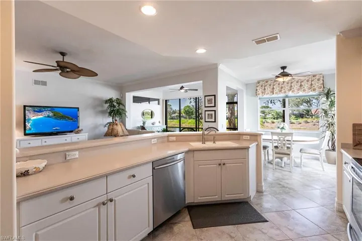 Kitchen featuring white cabinetry, open to living area