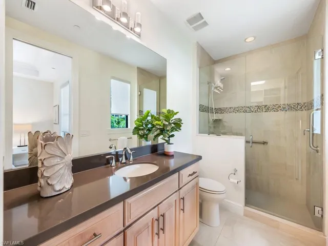 Bathroom featuring vanity, a stall shower, light tile patterned floors, and recessed lighting