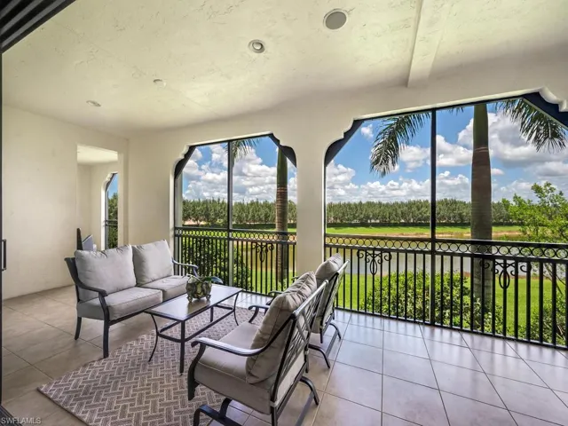 Sunroom / solarium with view of wooded area and a water view