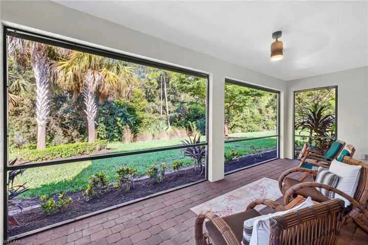Sunroom / solarium featuring view of scattered trees