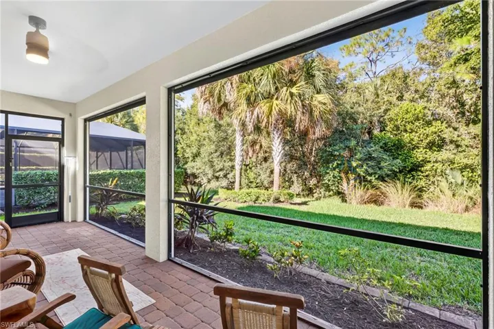 Sunroom / solarium featuring view of wooded area