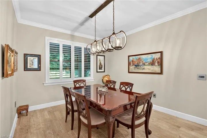 Dining area with ornamental molding and light wood-style floors