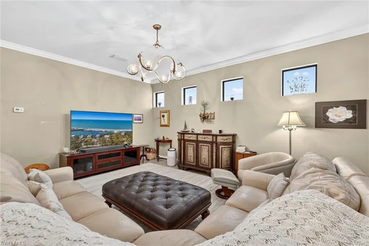 Living room featuring ornamental molding and a chandelier