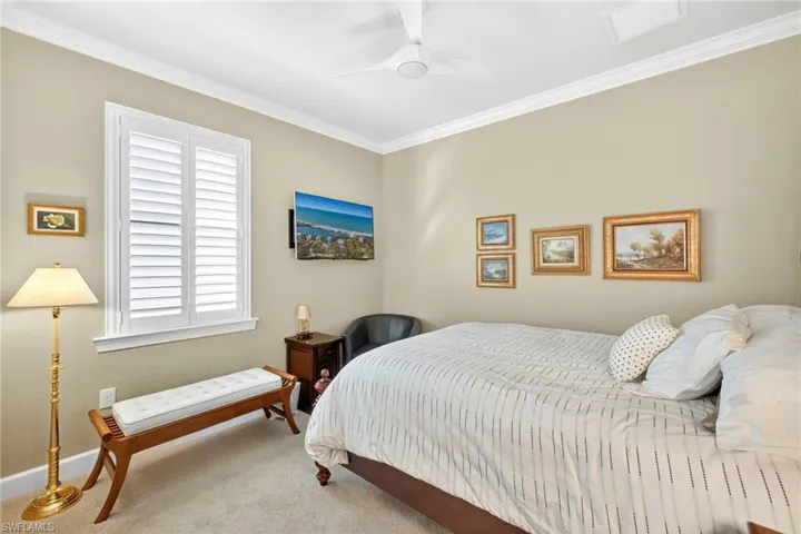 Carpeted bedroom featuring ornamental molding and ceiling fan