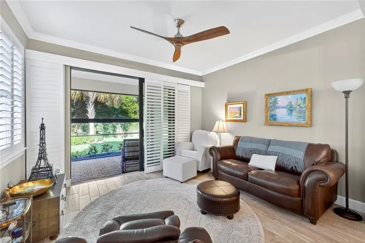 Living area with ornamental molding, a ceiling fan, and wood finished floors