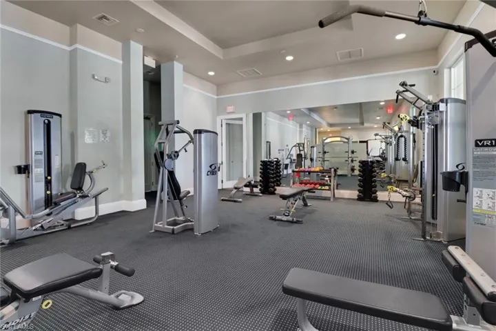 Workout area featuring recessed lighting and a tray ceiling