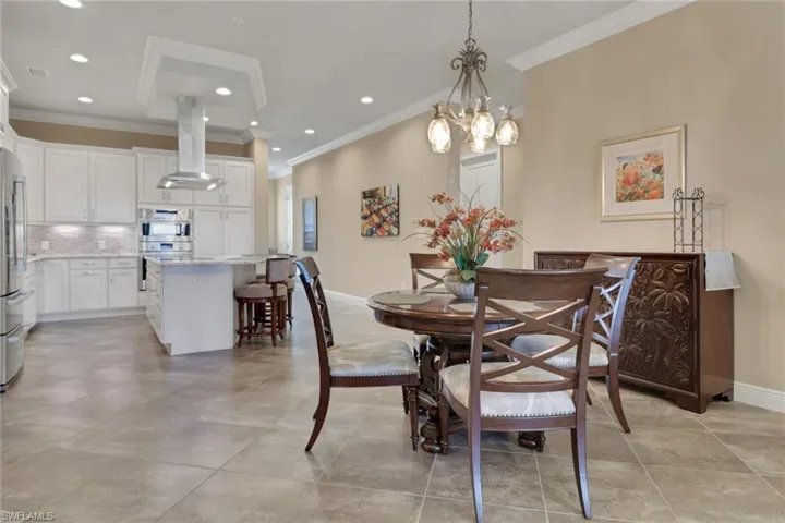 Dining area featuring ornamental molding, recessed lighting, light tile patterned floors, and a chandelier
