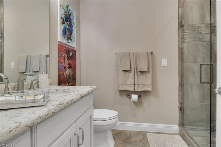 Bathroom with a shower stall, vanity, and light tile patterned floors
