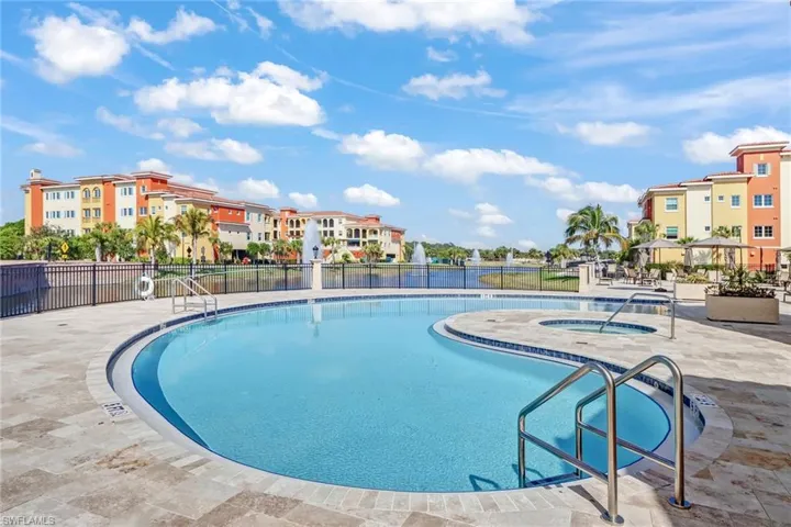 Community pool featuring a patio area, a residential view, and a hot tub