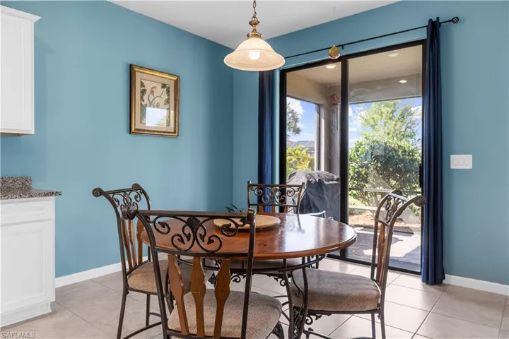 Dining area with a view of the screened lanai and yard. 16009 Palmetto Prairie Drive.  Hampton Lakes at River Hall.