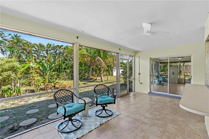 Unfurnished sunroom featuring a ceiling fan