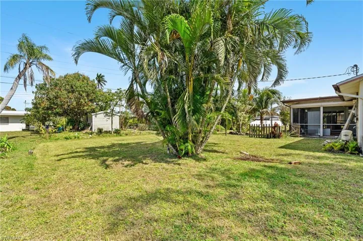 View of yard featuring a sunroom and fence