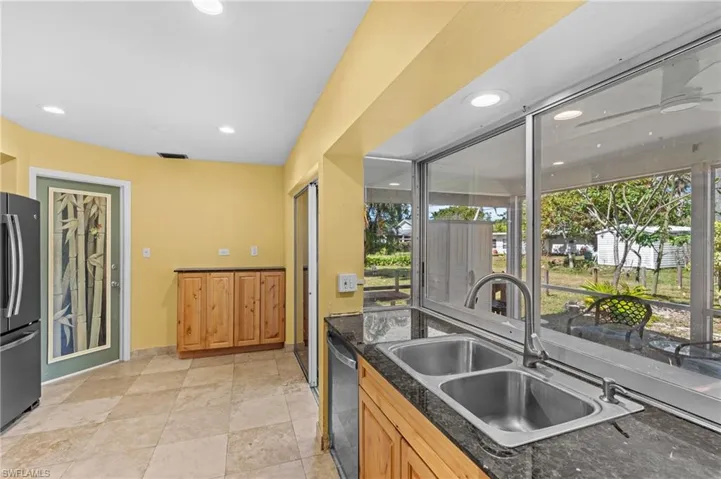 Kitchen featuring appliances with stainless steel finishes, dark stone counters, a sink, and recessed lighting