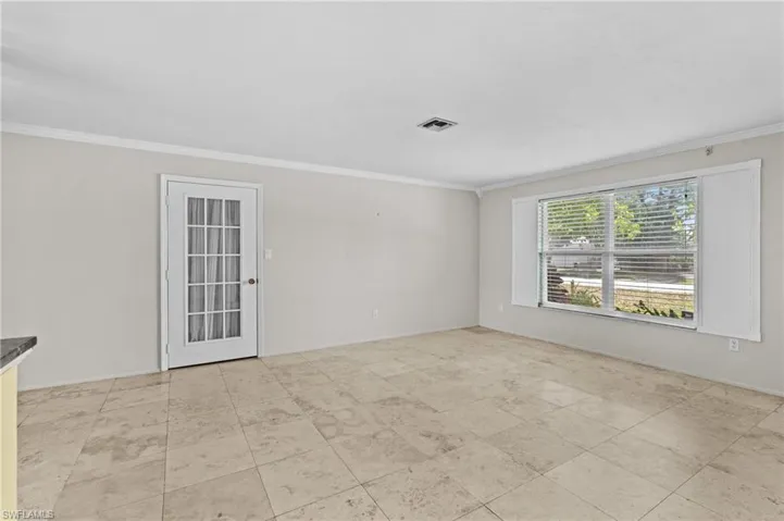 Empty room featuring visible vents and crown molding