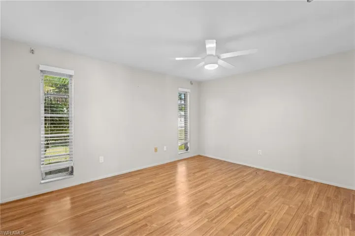 Empty room featuring a ceiling fan, light wood-style flooring, and baseboards