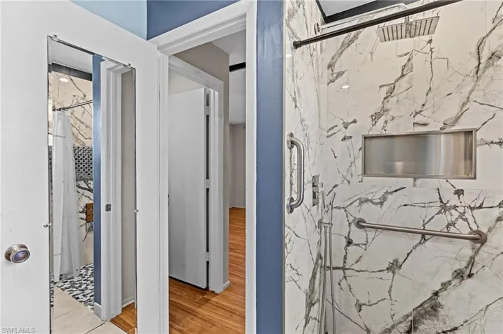 Bathroom with wood finished floors and a marble finish shower