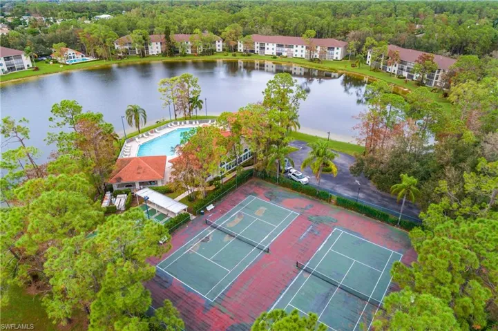 Drone / aerial view featuring tennis courts and club/pool