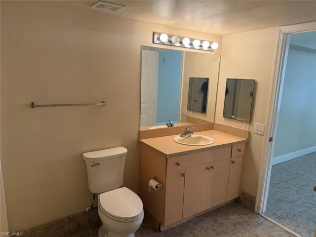 Bathroom with vanity and dark tile patterned flooring