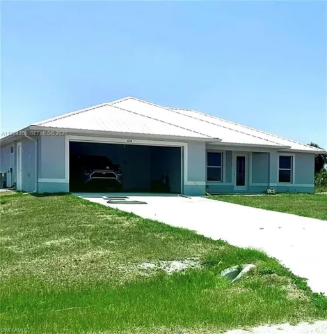 Light blue stucco exterior with a white metal roof