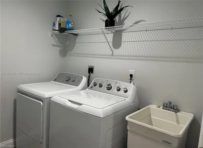 Dedicated laundry area featuring a utility sink and wire shelving