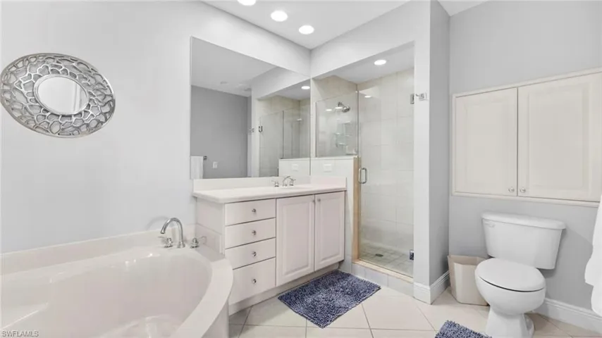 Full bathroom with tile patterned flooring, vanity, toilet, and independent shower and bath