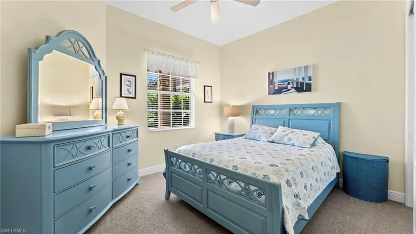 Bedroom with ceiling fan and light colored carpet