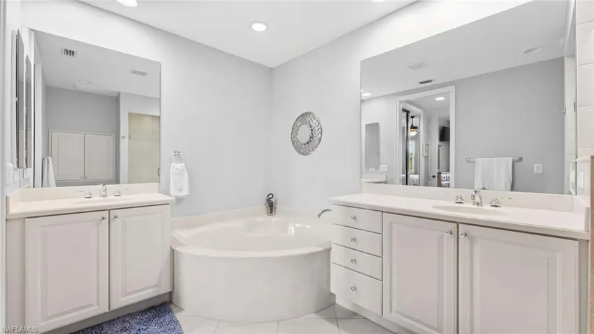 Bathroom featuring a bathtub, tile patterned flooring, and vanity