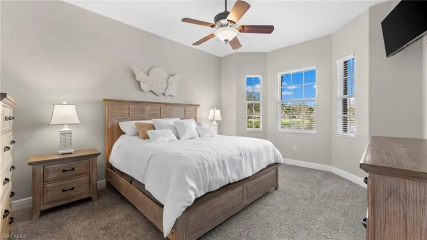 Bedroom with dark colored carpet and ceiling fan