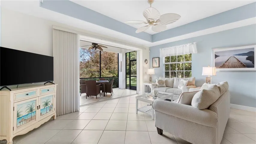 Living room featuring light tile patterned floors and ceiling fan
