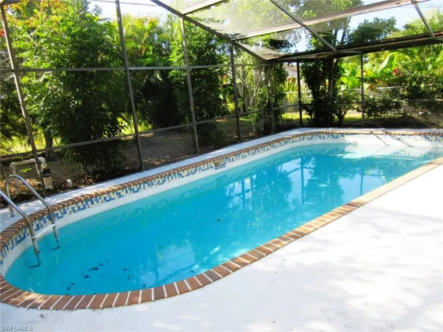 Outdoor pool featuring glass enclosure and a sunroom