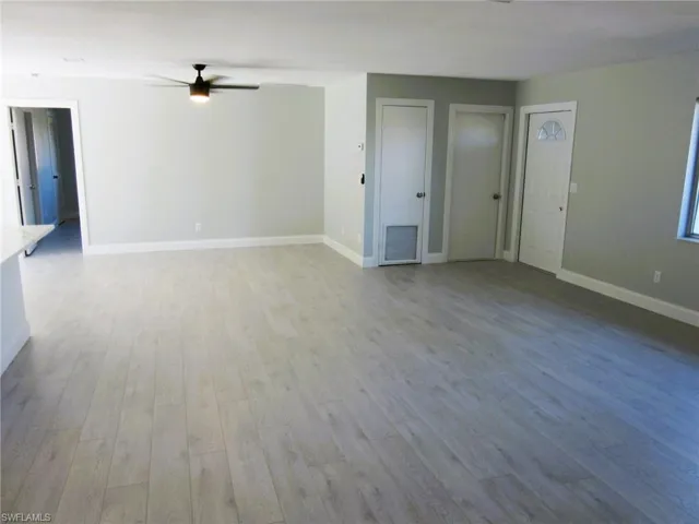 Unfurnished living room featuring light wood-type flooring and a ceiling fan